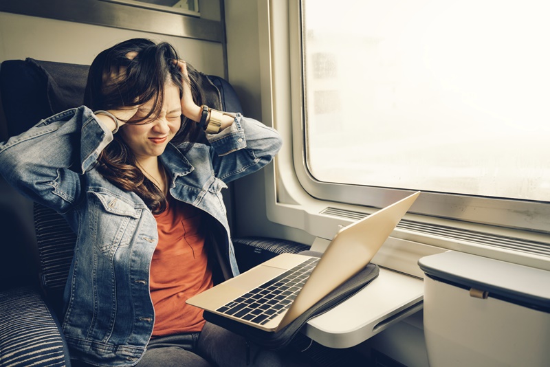 Asian college girl frustrated with laptop on the train
