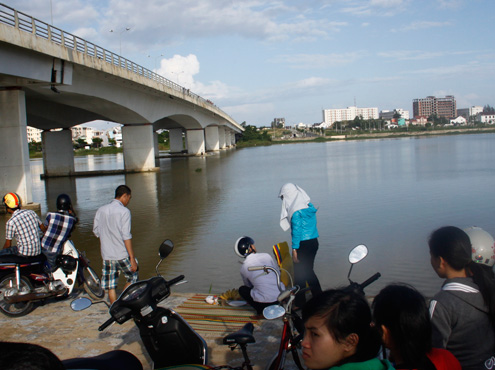 Người thân và bạn bè của nạn nhân tập trung ở bờ sông, tự thuê thuyền tìm kiếm. Ảnh: Nguyễn Đông