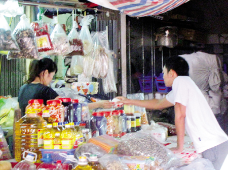 Chủ hàng khô tại chợ Ngã Tư Sở đang bán đường hóa học cho khách hàng (ảnh chụp chiều 6/11).