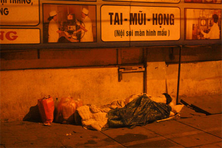 Một người lỉnh kỉnh đồ đạc trên vỉa hè phố Trần Hưng Đạo rạng sáng ngày 25/11.