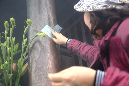 Du khách chen nhau lấy may bằng cách xoa tiền lẻ vào chùa Đồng.