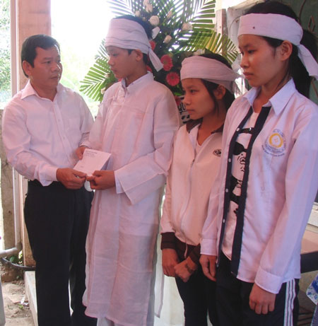 Giám đốc Sở GTVT Quảng Ngãi (bìa trái) hỗ trợ cho gia đình nạn nhân Đặng Thị Kim Hoa