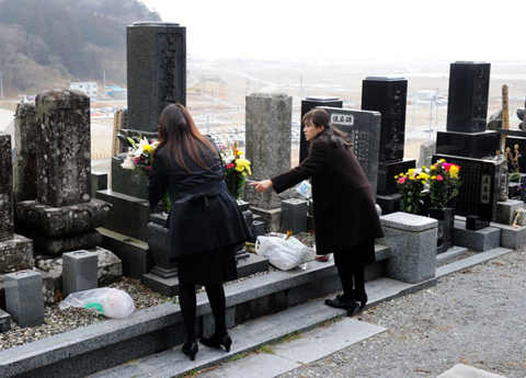 Hai phụ nữ mang hoa tới mộ