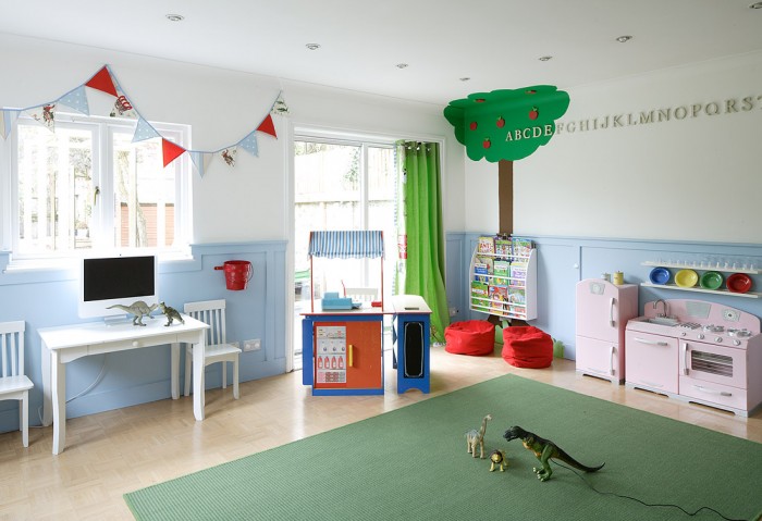 apple tree mural and bunting clad child's playroom in white and baby blue