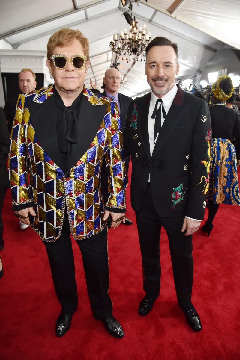 Elton John (trái) và bạn đời David Furnish mặc trang phục "hàng thửa" từ thương hiệu Gucci. Sắp tới trong tour lưu diễn vòng quanh thế giới kéo dài trong 3 năm của Elton John, Gucci cũng hân hạnh "đồng hành" với những bộ trang phục đặc sắc cho nam danh ca lừng lẫy người Anh này. 