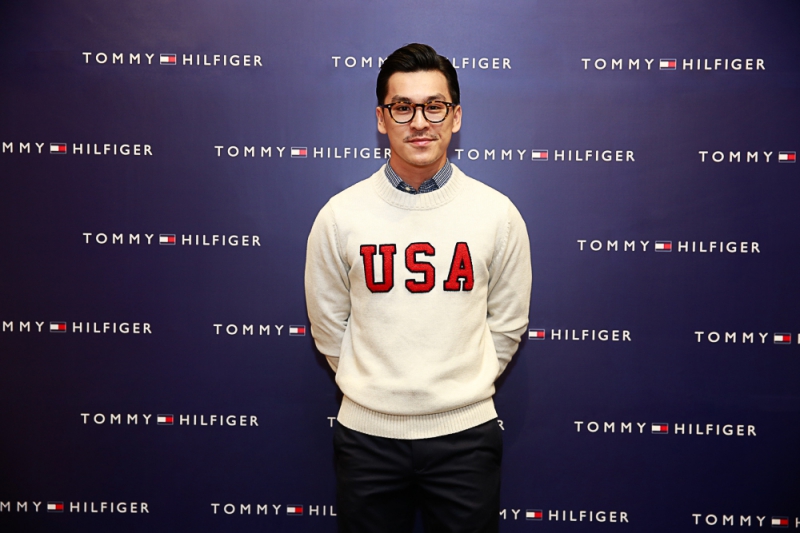 Nhiếp ảnh gia Thiên Minh trong một thiết kế sweater với dòng chữ USA mang phong cách preppy trẻ trung của Tommy Hilfiger. 