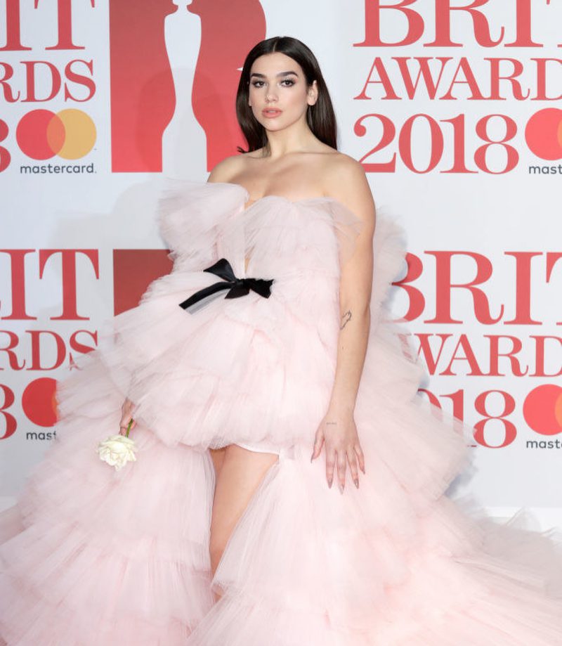 Tại Lễ trao giải Brit Awards 2018 hồi tháng 2 vừa qua, Dua Lipa đã xuất hiện trên thảm đỏ như một nàng công chúa trong thiết kế couture của Giambattista Valli. Những tầng vải tulle bồng bềnh tựa như những đám mây tôn lên vẻ đẹp quyến rũ của Dua Lipa. 