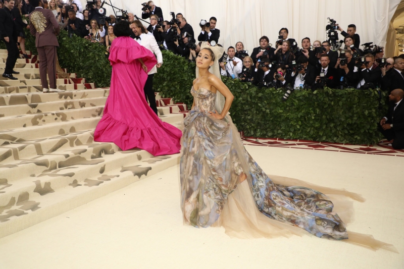 Ariana Grande mặc thiết kế đầm công chúa của Vera Wang với những lớp vải tulle mềm mại, tạo độ thướt tha cho trang phục. Họa tiết trên bộ trang phục là những bức vẽ của Michelangelo trên trần nhà nguyện Sistina ở Thành Vatican. 