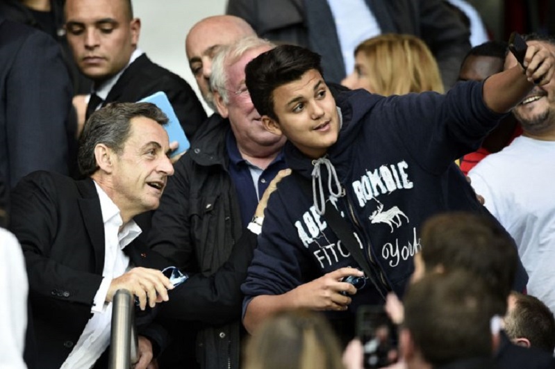Cựu Tổng thống Pháp Nicolas Sarkozy (trái) chụp ảnh tự sướng cùng một bạn trẻ khi theo dõi trận đấu bóng đá giữa hai đội tuyển Paris Saint-Germain (PSG) và Reims tại sân vận động Parc des Princes ở thủ đô Paris ngày 23/5/2015.