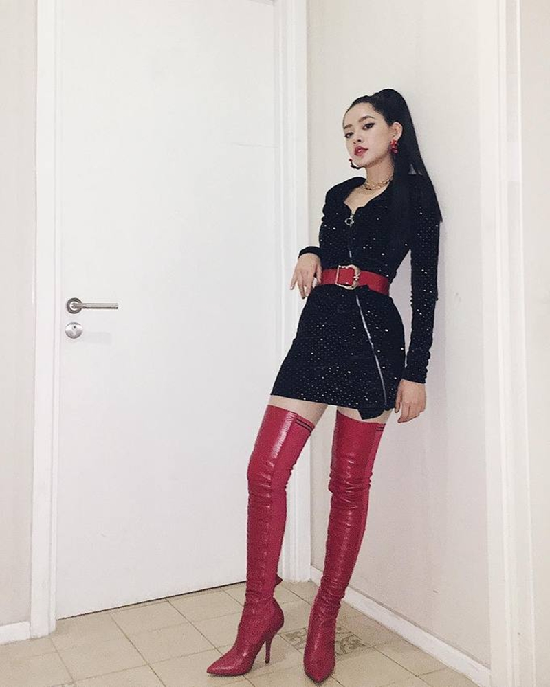 Chi Pu lại chọn kiểu boots đỏ cổ cao để phối cùng bộ váy đen của mình.