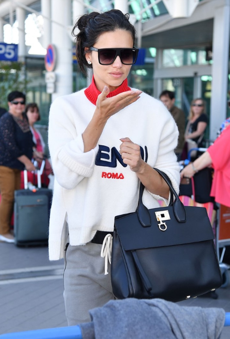 "Thiên thần" Adriana Lima xuất hiện trẻ trung tại sân bay với túi Studio đen.