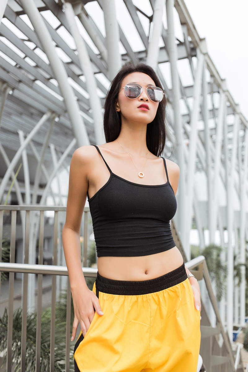Nguyễn Thanh năng động với trang phục phong cách thể thao mang tông vàng - đen cùng kính mắt tráng gương tạo điểm nhấn. 