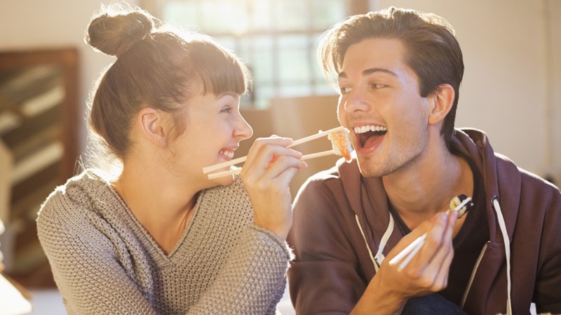 Couple eating sushi together in new home