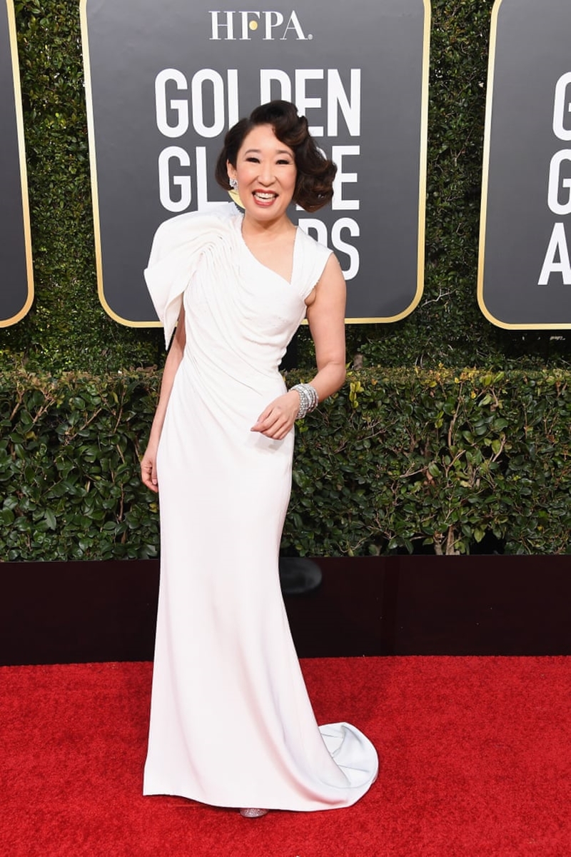 Chủ xị của Quả Cầu Vàng 2019 là nữ diễn viên Sandra Oh. Cô mặc thiết kế đầm trắng sang trọng của Versace. 