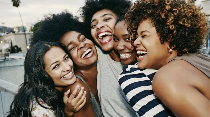 Women laughing together on urban rooftop